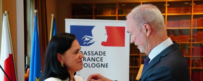 Mężczyzna przypina kobiecie odznaczenie. 