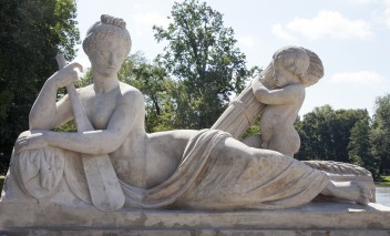 Rzeźba Wisły przedstawiająca półleżącą i półnagą kobietę, wspierającą się na wiośle, obok niej stoi mały chłopczyk, trzymający snop zboża