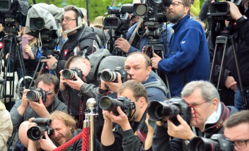 Grupa osób z aparatami fotograficznymi i kamerami.