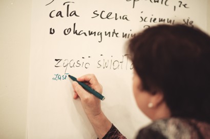 Kobieta pisząca mazakiem na tablicy.