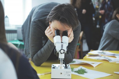 Osoba patrząca przez mikroskop.