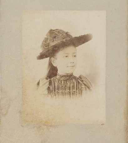 Archiwalne zdjęcie młodej dziewczyny w kapeluszu i sukience z epoki. 