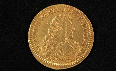 Stara, złota moneta przedstawiająca popiersie mężczyzny. 