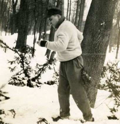 Mężczyzna stoi na śniegu w parku i ćwiczy.