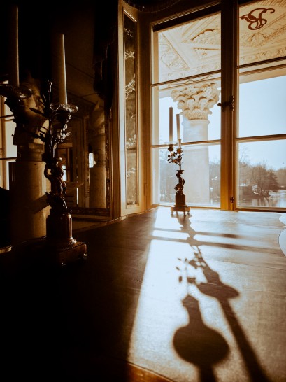 Sala w Pałacu na Wyspie. Na wprost widoczne jest duże okno, za oknem znajduje się kolumna. Po ścianą w sali znajduje się rzeźba.