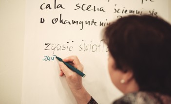 Kobieta pisząca mazakiem na tablicy.