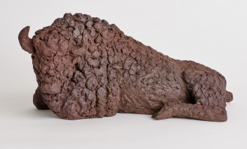 Rzeźba z gliny przedstawiająca leżącego żubra.