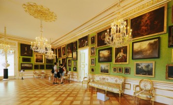 Galeria Obrazów. Na ścianach wiszą obrazy, które ogląda grpa osób. 