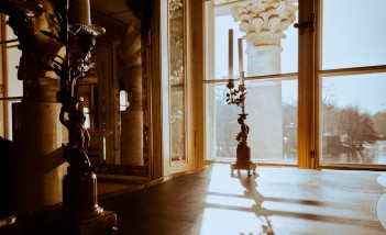 Sala w Pałacu na Wyspie. Na wprost widoczne jest duże okno, za oknem znajduje się kolumna. Po ścianą w sali znajduje się rzeźba. 