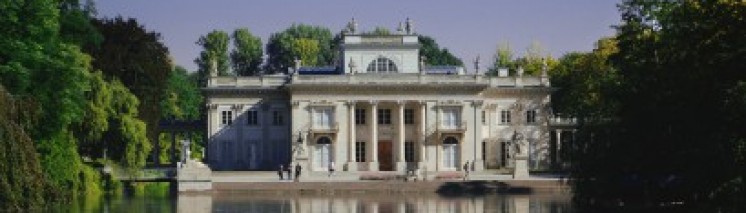 Pałac na Wyspie w otoczniu drzew i wody.