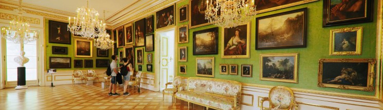 Galeria Obrazów. Na ścianach wiszą obrazy, które ogląda grpa osób. 