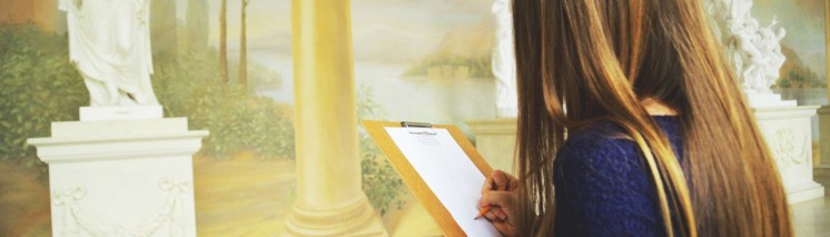 Trzy dziewczyny przed rzeźbą przedstawiającą kobietę owiniętą w szaty szkicują posąg.